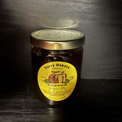 Jar of jalapeno jelly with a yellow label and metal lid