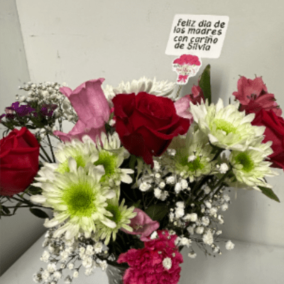 Bouquet of red roses, pink lilies, and white daisies in a vase