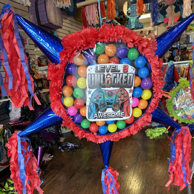 Colorful piñata shaped like a game controller with long streamers