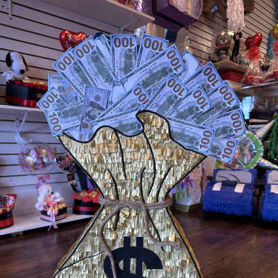 Money bag-shaped gift display with faux dollar bills and a large dollar sign