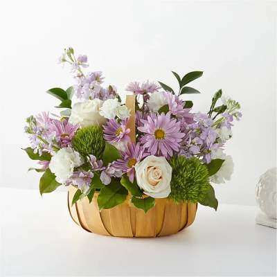 Short wooden basket of lavender daisies, white roses and carnations, and green mums