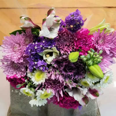 Bouquet of purple, pink, and white flowers in a wrapped arrangement