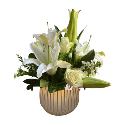 White lilies and roses arranged in a ribbed vase