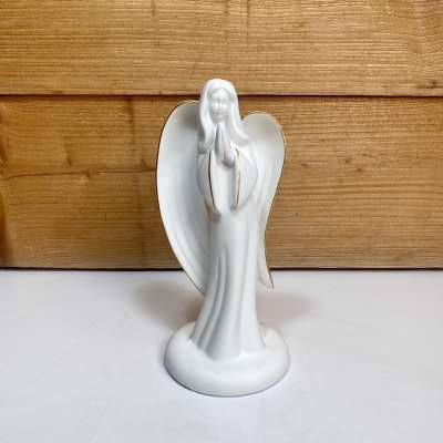 White angel figurine with gold trim standing on a base