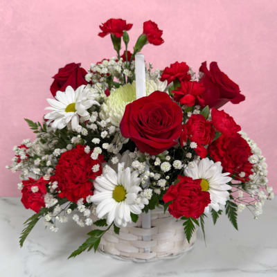 Basket arrangement of red roses, carnations, and white daisies