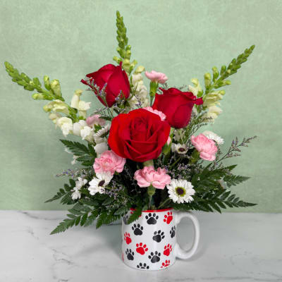 Red roses and pink carnations in a paw-print mug