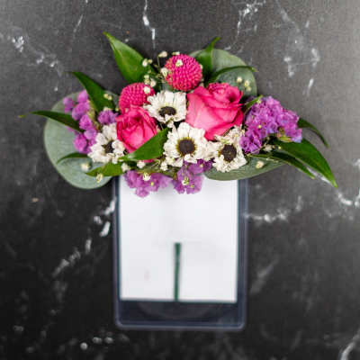 Pink roses and white daisies arranged in a rectangular vase
