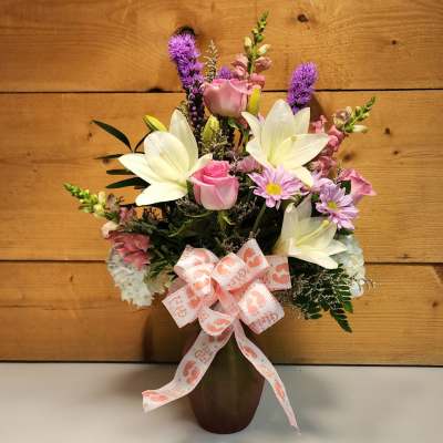 Pink and white mixed bouquet in a vase with a baby girl ribbon