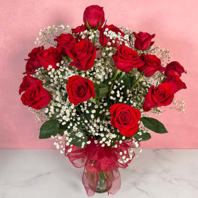 Bouquet of red roses with white baby's breath in a glass vase