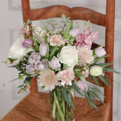 Pastel bouquet of roses, tulips, and chrysanthemums in a glass vase