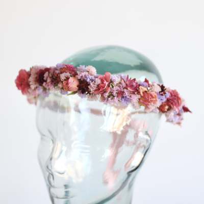 Floral crown of pink and purple flowers on a glass mannequin head