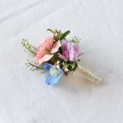 Small pastel boutonniere with pink, purple, and blue flowers