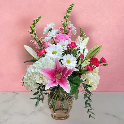 Pink and white mixed flower arrangement in a glass vase