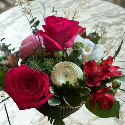 Pink and white roses with red alstroemeria in a dark vase
