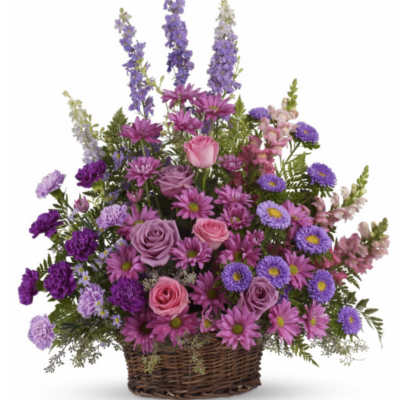 Purple and pink mixed flower basket in a wicker container
