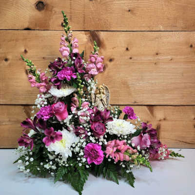 Pink and white floral arrangement with a small angel figurine