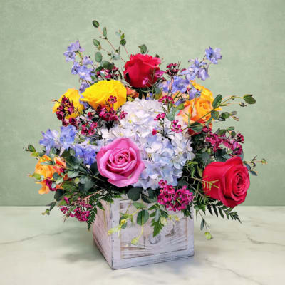 Colorful bouquet of roses and hydrangeas in a wooden box
