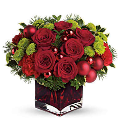 Red roses and green mums in a red glass vase with ornaments