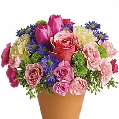 Mixed pink and purple flower arrangement in a brown pot