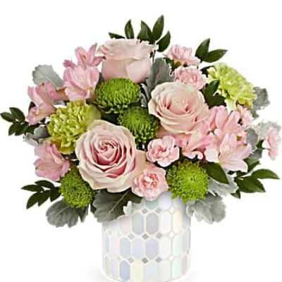 Pink and green floral arrangement in a patterned vase