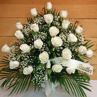 White roses arranged in a vase with a "Loving Brother" ribbon