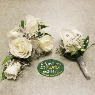 White rose boutonnieres with silver ribbon and rhinestone accents