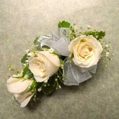 Cream rose corsage with silver ribbon and small white filler flowers