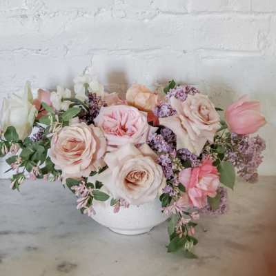 Pastel rose and tulip arrangement in a white bowl vase