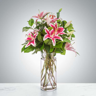 Pink lilies arranged in a clear glass vase