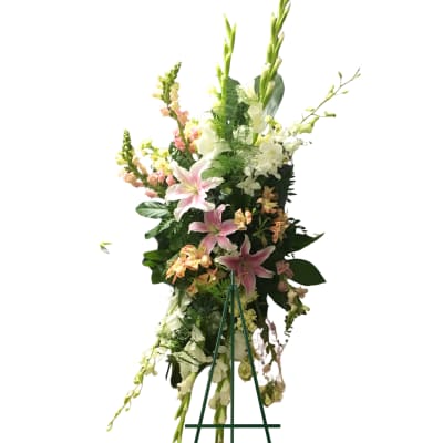 Tall floral standing spray with pink lilies and white blossoms on an easel