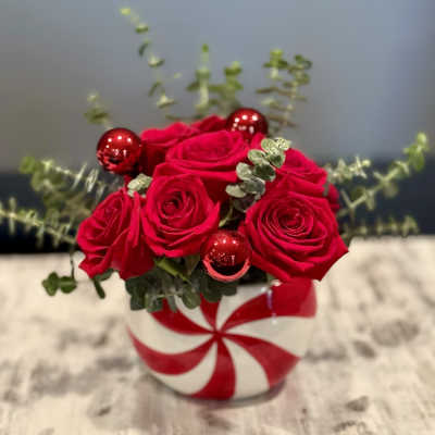 Red roses in a striped round vase with red ornaments