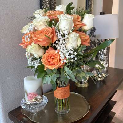 Bouquet of peach and white roses in a glass vase