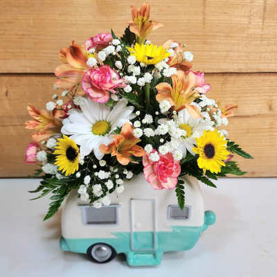 Mixed flower arrangement in a camper-shaped ceramic container
