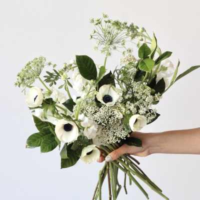 Handheld bouquet of white anemones and airy greenery