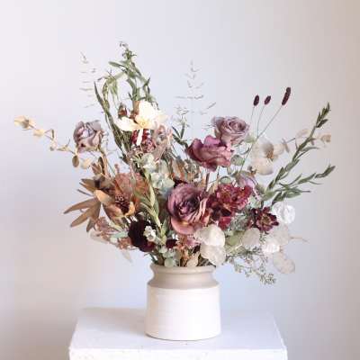 Mixed bouquet in a white ceramic vase with mauve and cream flowers