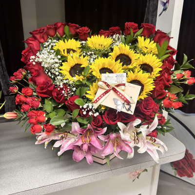 Large bouquet of red roses, sunflowers, and pink lilies in a box
