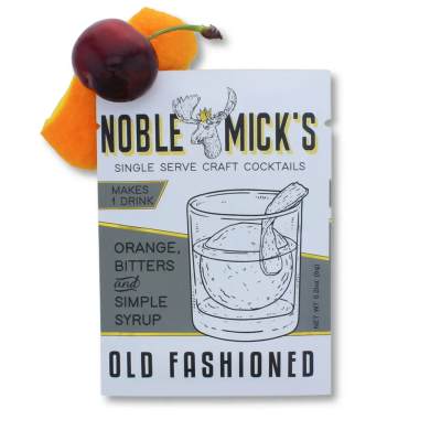 Old Fashioned cocktail mix packet with orange peel and cherry garnish