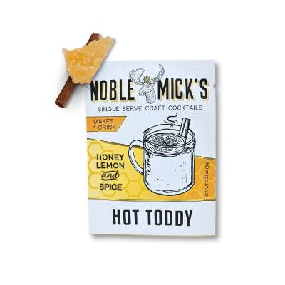 Hot toddy cocktail mix packet with a cinnamon stick and dried citrus garnish