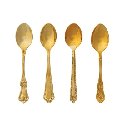 Four gold-colored decorative spoons on a white background