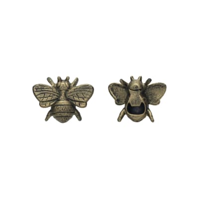 Two small bee-shaped metal ornaments on a white background