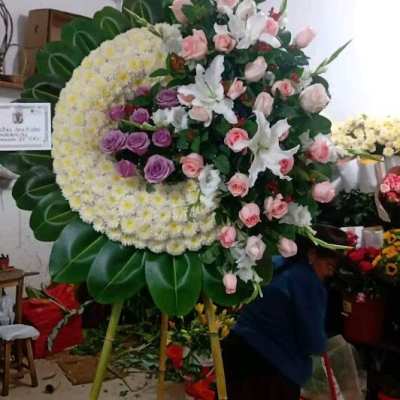 Large standing floral wreath with pink and white roses and lilies