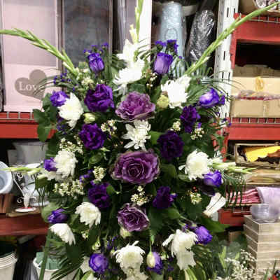 Purple and white floral standing spray on an easel