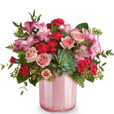 Pink roses and lilies arranged in a pink glass vase