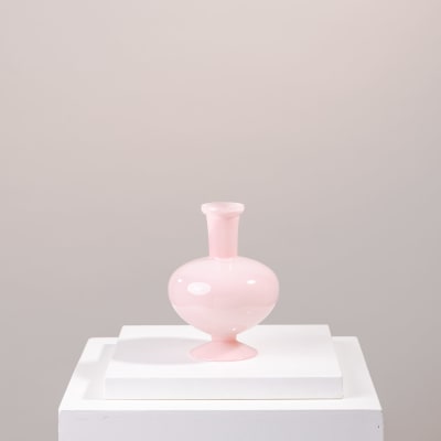 Pink glass vase on a white pedestal