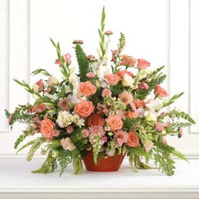 Peach and pink mixed flower arrangement in a terracotta pot