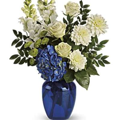 White and blue floral arrangement in a cobalt glass vase