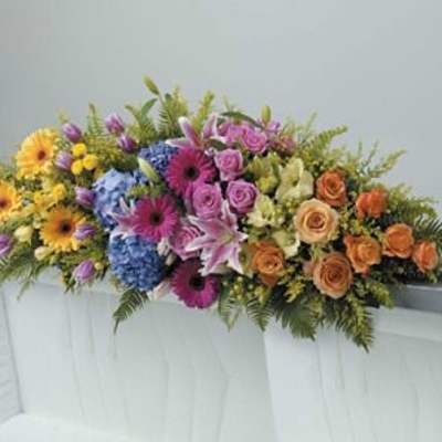 Colorful floral spray with roses, gerbera daisies, lilies, and hydrangeas