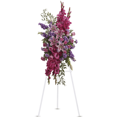 Tall standing floral spray with pink lilies and purple flowers on an easel