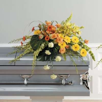 Colorful floral casket spray with yellow and orange blooms