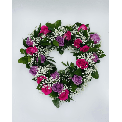 Heart-shaped arrangement of pink and purple roses with white baby's breath